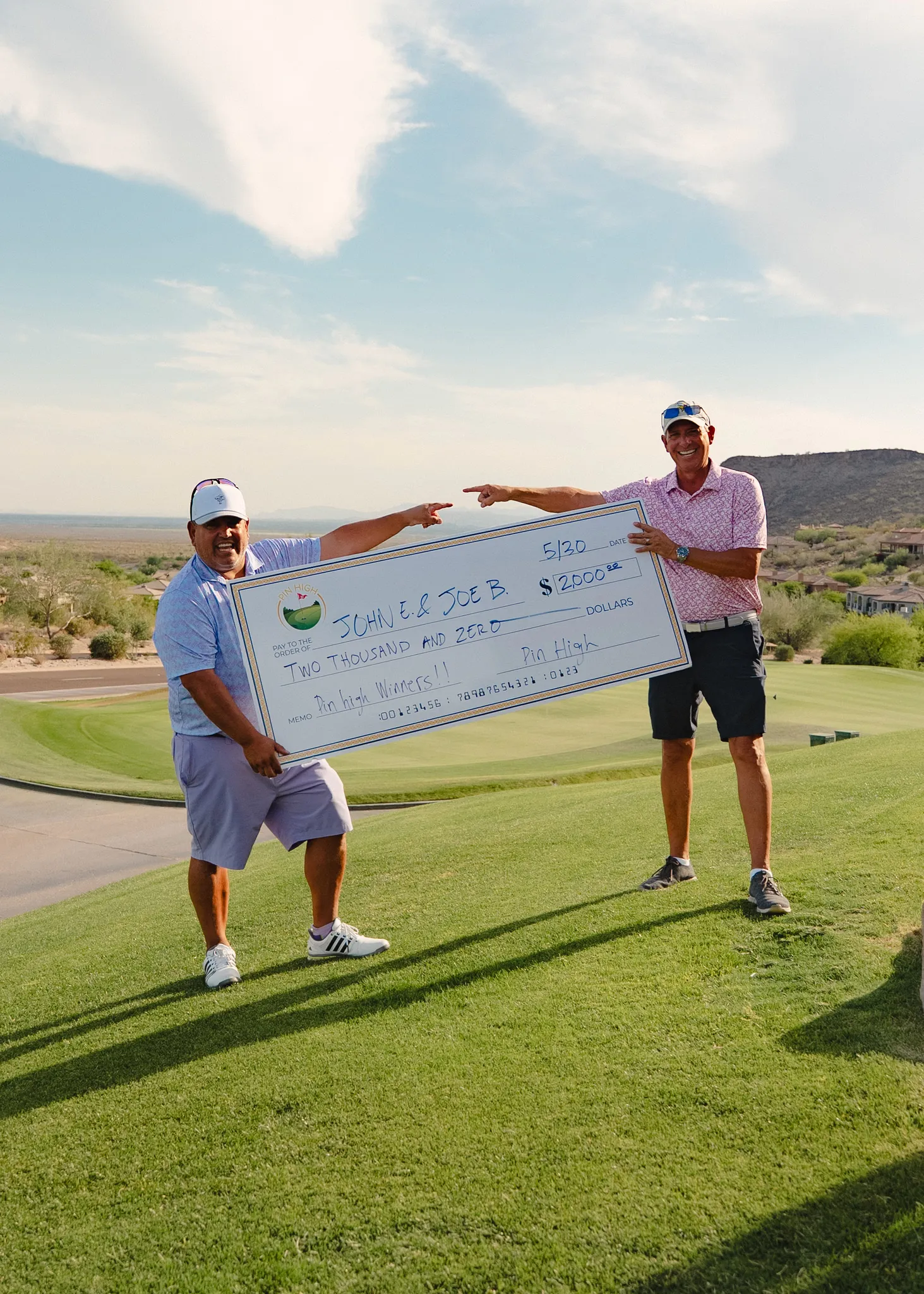Pin High winners holding a two-thousand-dollar prize check